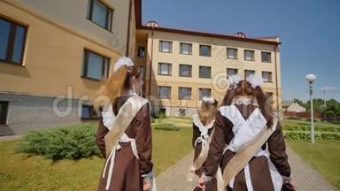 女学生毕业生们正沿街走着。 俄罗斯毕业生庆祝最后一个学年。